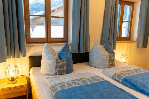 a bedroom with two beds with blue and white pillows at Ferienwohnungen Heillinger Gütl in Ruhpolding