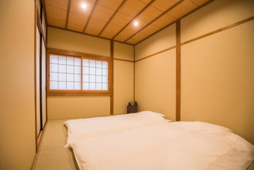 a room with two beds in it with a window at 京町　朱雀 in Kyoto