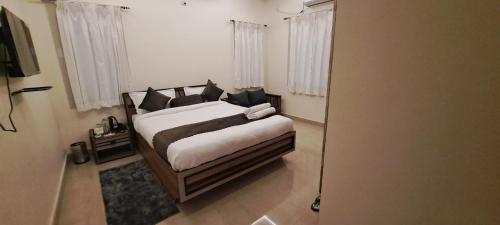 a bedroom with a bed with white sheets and black pillows at The Candy Nest in Rānchī