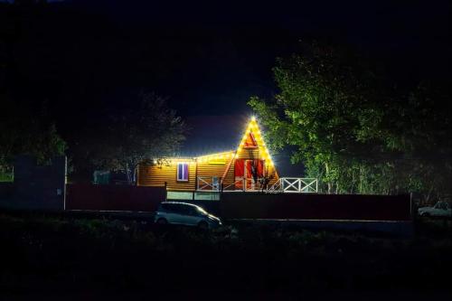 a large wooden house with a lit up facade at night at Sionis Idilia in Sioni
