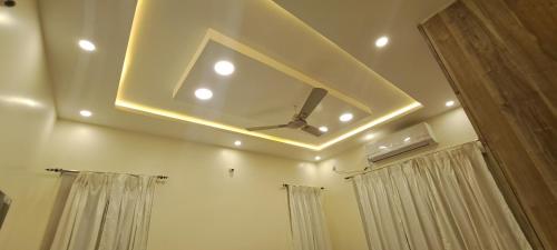 a bathroom with a ceiling with a fan and curtains at The Candy Nest in Rānchī