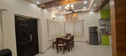 a dining room with a table and chairs and a refrigerator at The Candy Nest in Rānchī