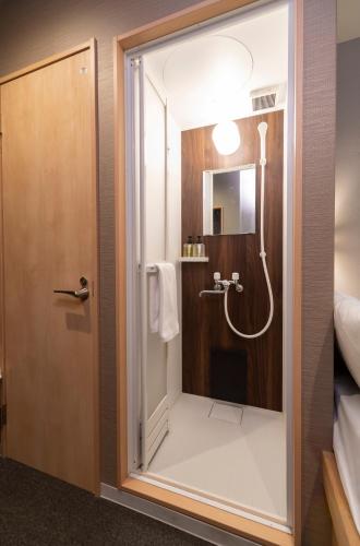 a bathroom with a shower with a glass door at Boxi Hakata 1 in Fukuoka