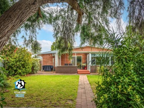 a brick house with a tree in the yard at Renovated 3BR One Street to Beach in Victor Harbor