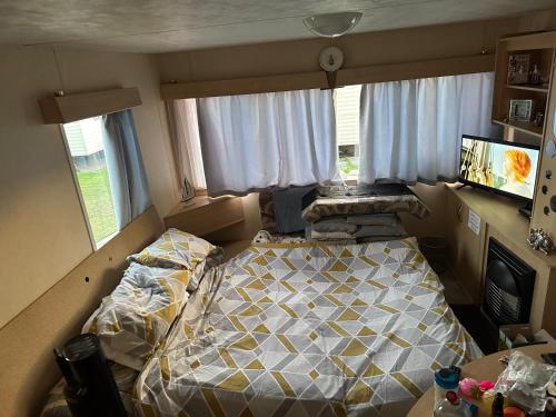 um quarto com uma cama num quarto com janelas em BUMBLEBEE rhyl em Rhyl