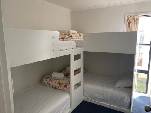 a bedroom with two bunk beds and a window at BIG4 Bays Holiday Park in Anna Bay