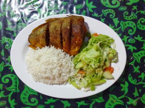 un plato blanco de comida con arroz y verduras en Mares gunayarIslas en Nusatupo