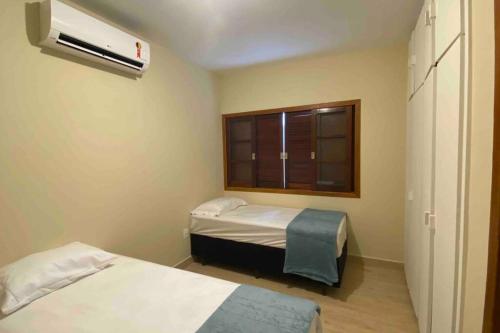 ein Krankenhauszimmer mit 2 Betten und einem Fenster in der Unterkunft Casa 5 - Vila Francisco in Pirenópolis