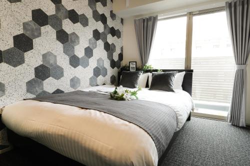 a bedroom with two beds and a patterned wall at Residence Hotel Hakata 19 in Fukuoka