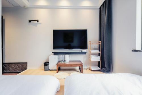 a living room with a bed and a tv at Tingjian Lingyin Alanruo Design Homestay in Hangzhou