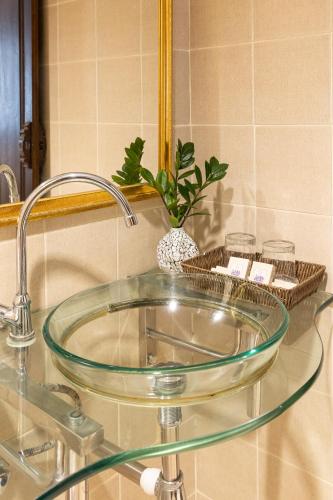 a glass sink in a bathroom with a mirror at Na Thapae Chiangmai Hotel in Chiang Mai