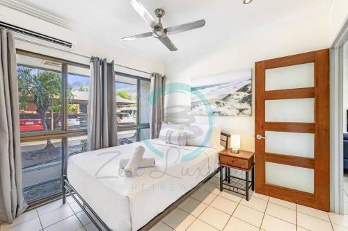 a bedroom with a bed and a window at Zen by the Coast: 2-BR Cozy Retreat Near Uni/Shops in Casuarina