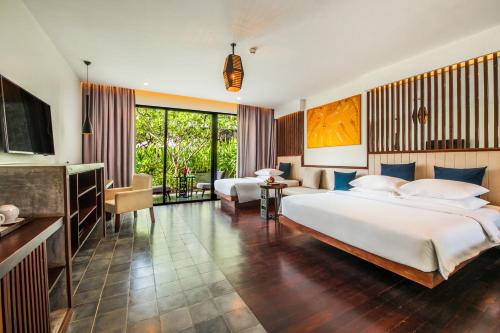 1 dormitorio con 2 camas y sala de estar en The Villa by Metta en Siem Riep