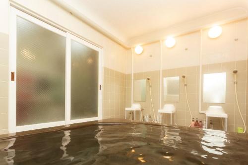 a room with a swimming pool with a large mirror at Villa Ortigia in Minamiawaji