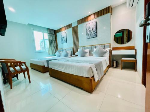 una camera d'albergo con due letti e uno specchio di KEN HOTEL ad Ho Chi Minh