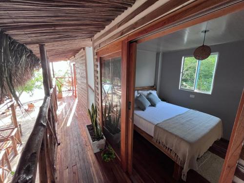 1 dormitorio con 1 cama y balcón en Thani Ecobeach Barú en Playa Blanca