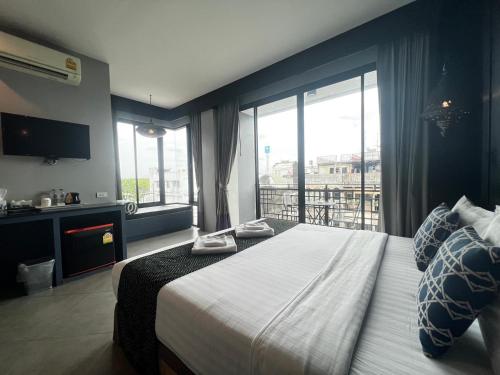a hotel room with a bed and a large window at Srisawara Casa Hotel in Krabi