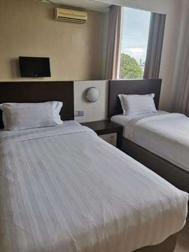 Habitación de hotel con 2 camas y ventana en 101 Hotel Bintulu, en Bintulu