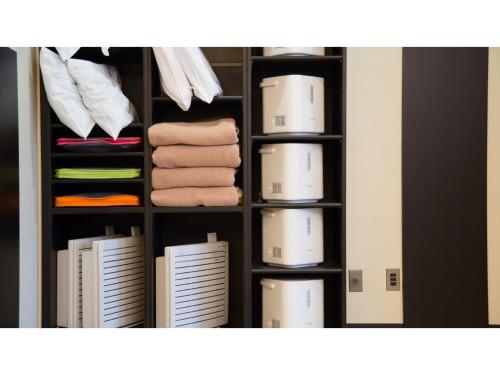um armário cheio de caixas e toalhas em Hotel Areaone Okayama - Vacation STAY 32493v em Okayama