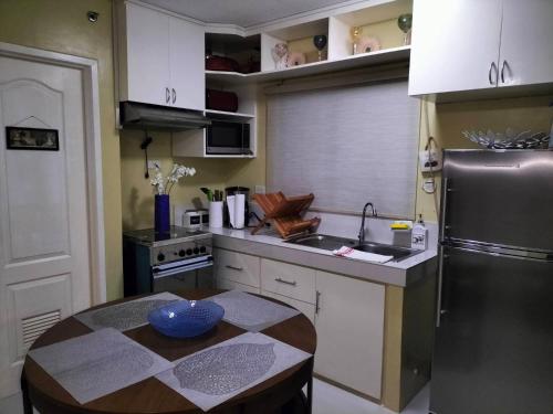 a kitchen with a table and a stainless steel refrigerator at City condo in Talisay