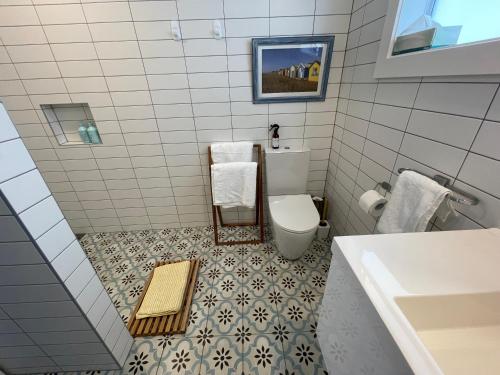 a bathroom with a toilet and a sink at Downtown Mount Cottage in Mount Maunganui