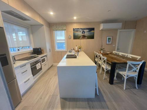 a kitchen with a counter and a table in a room at Downtown Mount Cottage in Mount Maunganui