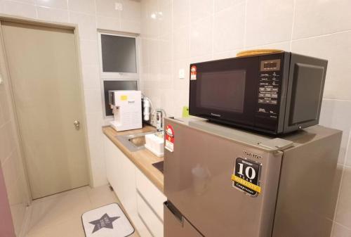 a microwave on top of a refrigerator in a kitchen at G Residence - 2R2B Barrington Night Market (1) in Brinchang