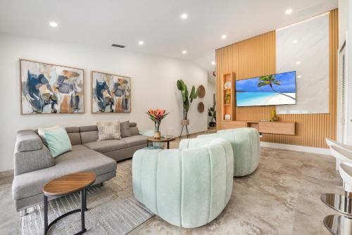 a living room with a couch and a tv at Flamingo's Resort 5 Bdrooms Gameroom Heated Pool in Miami