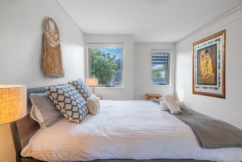 a bedroom with a large bed and two windows at Minnamurra Escape in Minnamurra