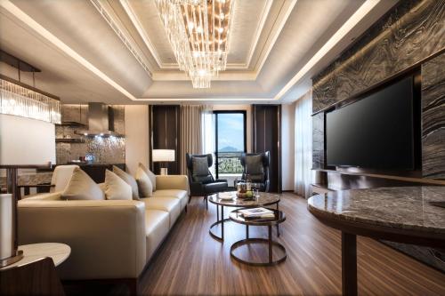 a living room with a couch and a tv at Hotel Valletta in Jiaoxi