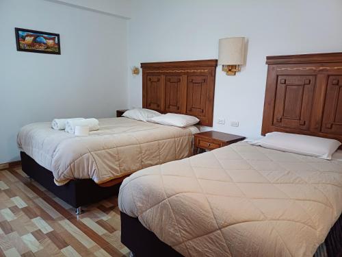 2 Betten in einem Hotelzimmer mit 2 Betten in der Unterkunft Apartamento familiar elegante 2 in Cusco