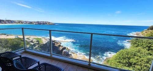 a balcony with chairs and a view of the ocean at Breathtaking Ocean Views in Sydney