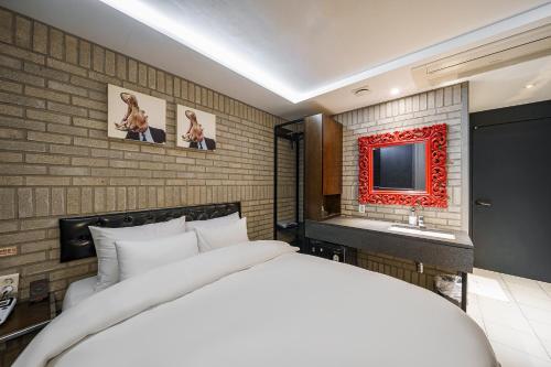 a bedroom with a white bed and a television at H-AVENUE Hotel Yeoksam in Seoul