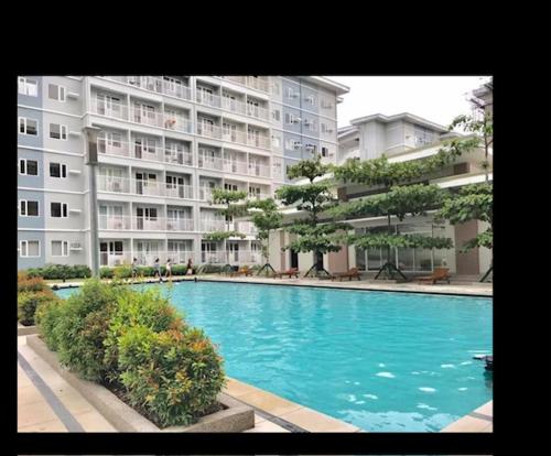 a large swimming pool in front of a large building at SMDC Trees Residence in Manila