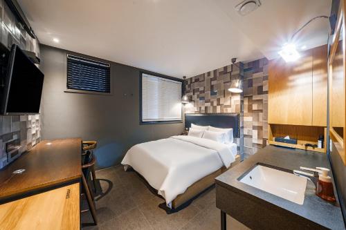 a bedroom with a bed and a sink in it at H-AVENUE Hotel Yeoksam in Seoul