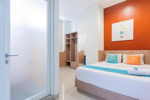 een slaapkamer met een bed en een glazen schuifdeur bij Sans Hotel Rajawali Surabaya by RedDoorz in Krembangan