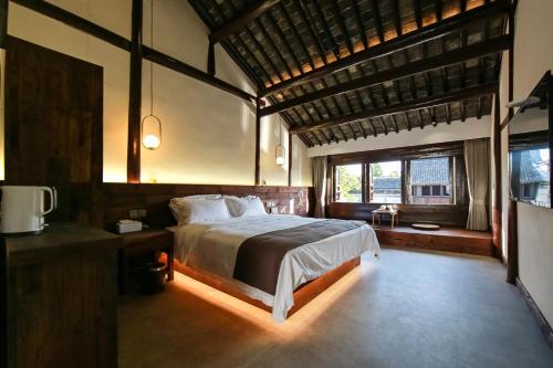 a bedroom with a bed and a large window at Tingjian Guli Private Bath Design Homestay - Nanxun Ancient Town Baijianlou Scenic Area in Huzhou