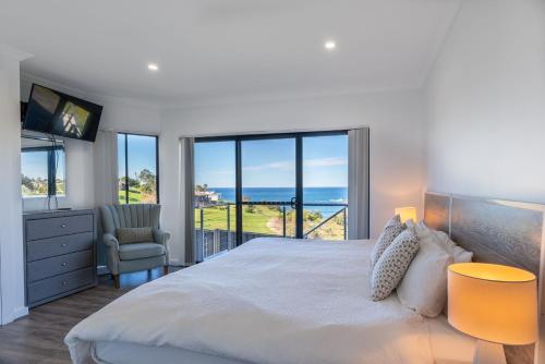 a bedroom with a bed and a view of the ocean at Sunrise on Easts 1 in Kiama