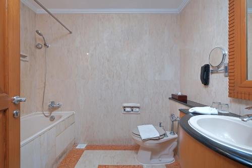 ein Badezimmer mit einem Waschbecken, einem WC und einer Badewanne in der Unterkunft Sunlake Waterfront Resort & Convention in Jakarta