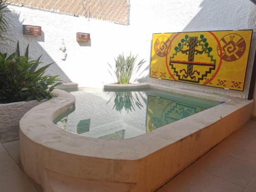 a swimming pool in a building with a sign at Casa Tolok in Mérida
