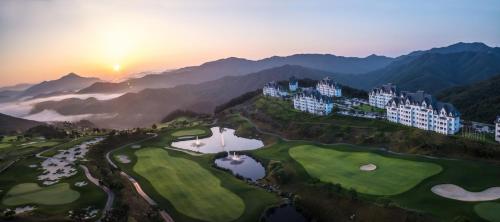 a view of a golf course with mountains in the background at Sono Felice Village VivaldiPark in Hongcheon