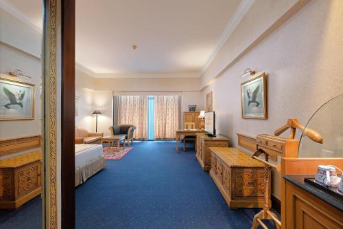 Pokój hotelowy z łóżkiem i biurkiem w obiekcie Sunlake Waterfront Resort & Convention w Dżakarcie