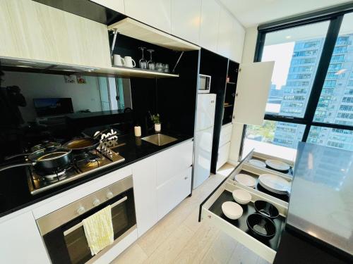 eine Küche mit Herd oberer Ofen neben einem Fenster in der Unterkunft Urban Chic Retreat near Crown w/ Free Parking in Melbourne