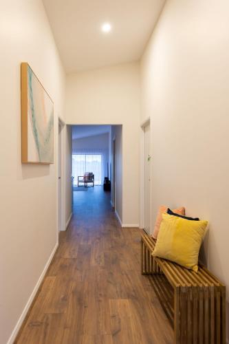 a living room with a couch and a yellow pillow at Eco Elegance in Cape Paterson in Cape Paterson