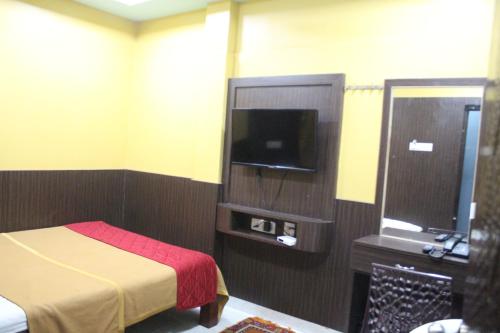 Habitación de hotel con cama, TV y baño. en gSR RESIDENCY en Kanchipuram