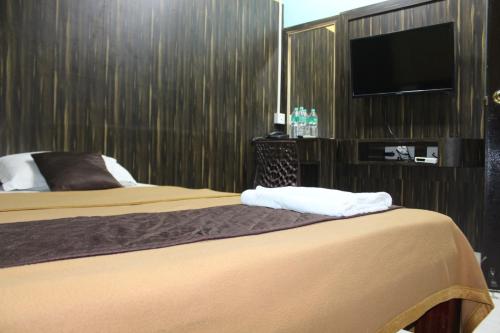 Habitación de hotel con 2 camas y TV de pantalla plana. en gSR RESIDENCY en Kanchipuram