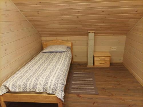 Zimmer mit einem Bett in einer Holzhütte in der Unterkunft Pirts Jaunakmeni in Priežmale