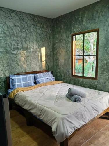 1 dormitorio con 1 cama grande con papel pintado verde en Pup Resort River View (ปั๊บ รีสอร์ท), en Mae Taeng