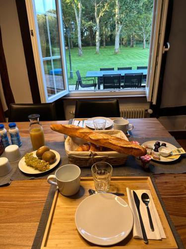 a table with bread and food on top of it at Chambre d’hôte in Chailly-en-Bière