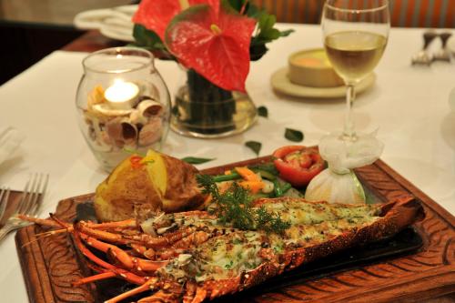a plate of food on a table with a glass of wine at Dar es Salaam Serena Hotel in Dar es Salaam